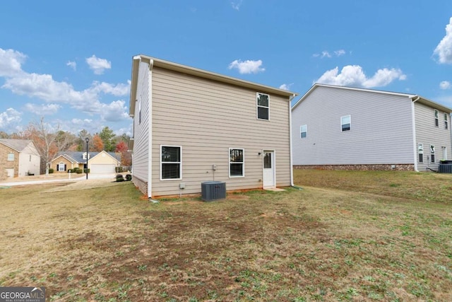 rear view of house with a yard and central AC unit