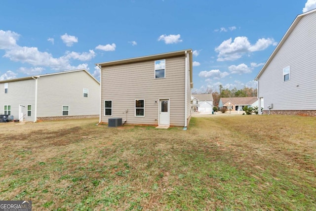 rear view of property featuring a yard and central air condition unit