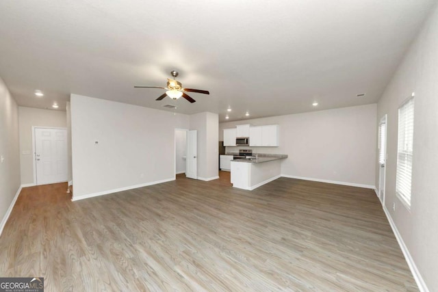 unfurnished living room with ceiling fan and light hardwood / wood-style floors