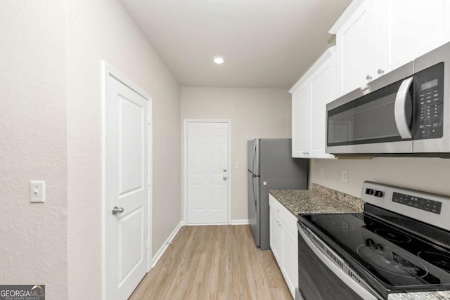 kitchen featuring light stone counters, light hardwood / wood-style flooring, stainless steel appliances, and white cabinets