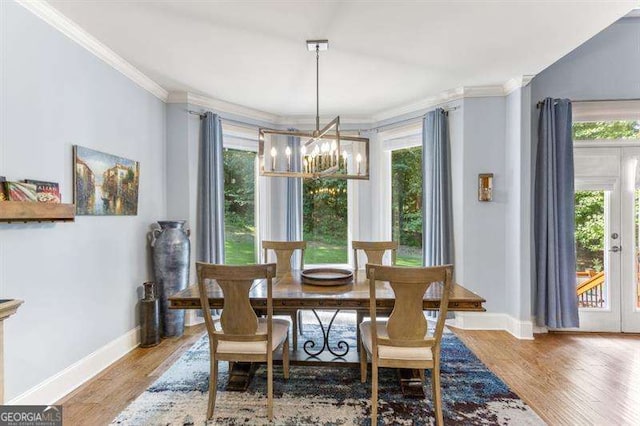 dining room featuring hardwood / wood-style flooring, crown molding, and a notable chandelier