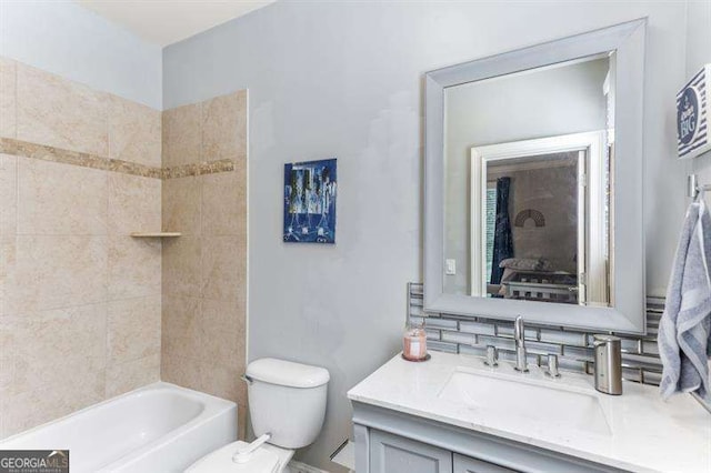 full bathroom with vanity, toilet, tiled shower / bath combo, and backsplash