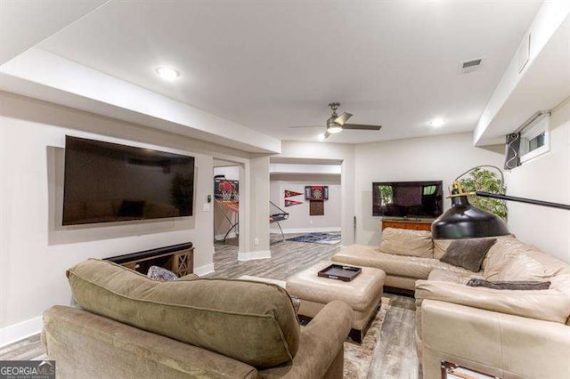 living room featuring a fireplace, light hardwood / wood-style flooring, and ceiling fan