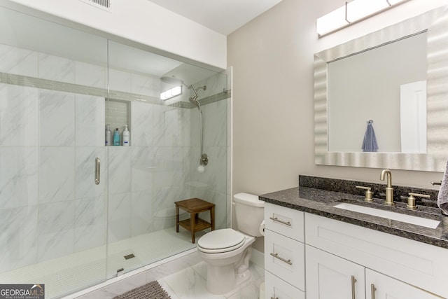 bathroom featuring vanity, toilet, and an enclosed shower