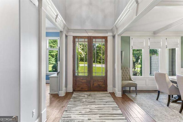 entrance foyer featuring light hardwood / wood-style floors, ornamental molding, and french doors