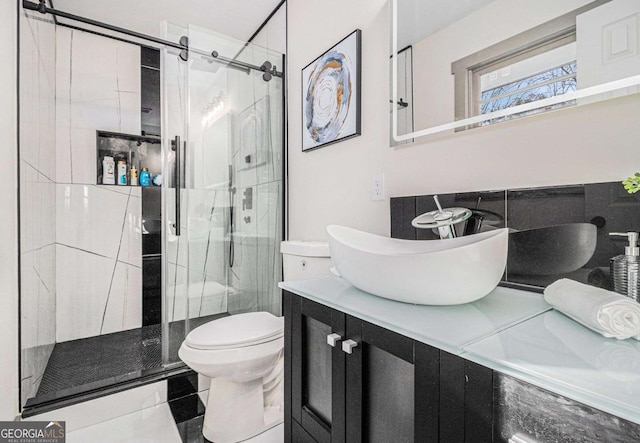 bathroom featuring vanity, toilet, and a shower with door