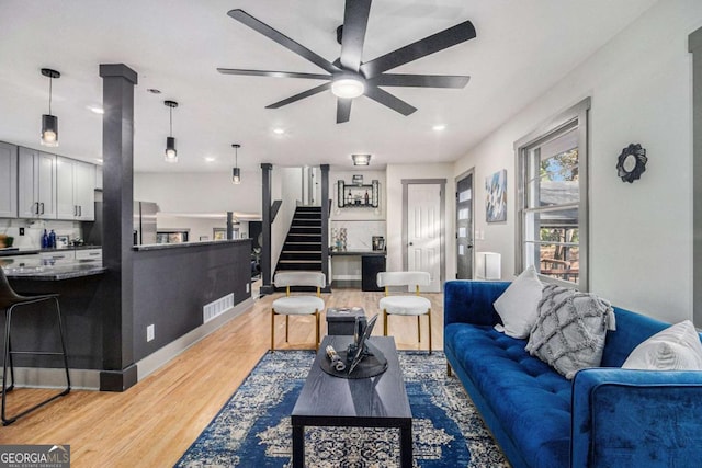 living room featuring light hardwood / wood-style floors and ceiling fan