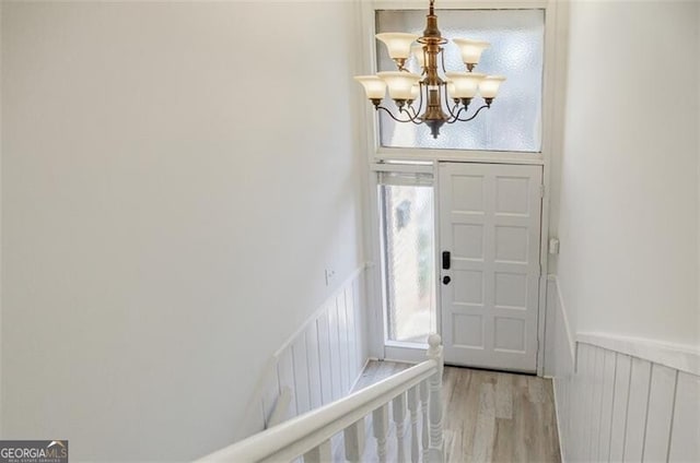 entryway featuring light wood-type flooring and a notable chandelier