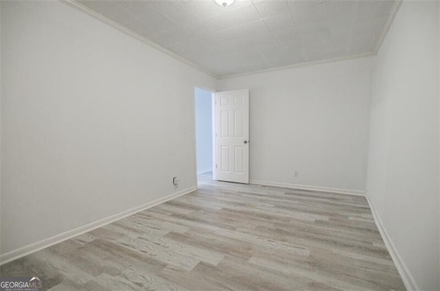 empty room featuring ornamental molding and light hardwood / wood-style floors