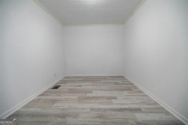 unfurnished room with ornamental molding and light hardwood / wood-style flooring