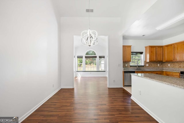 kitchen with pendant lighting, sink, decorative backsplash, stainless steel dishwasher, and dark wood-type flooring