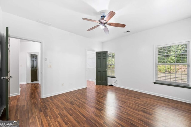 unfurnished room with dark hardwood / wood-style flooring, plenty of natural light, and ceiling fan