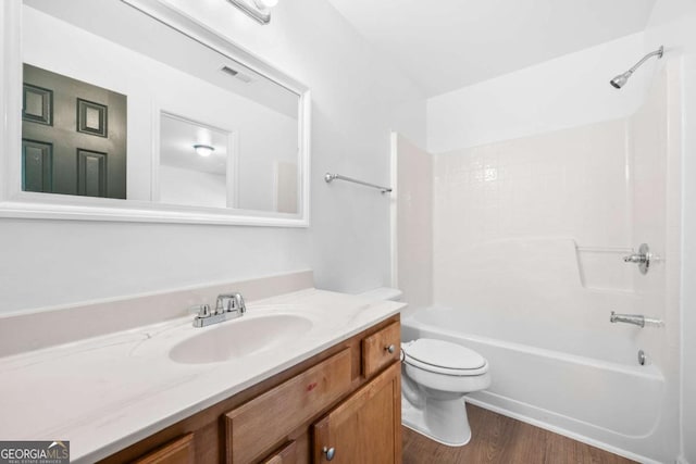 full bathroom featuring wood-type flooring, vanity,  shower combination, and toilet