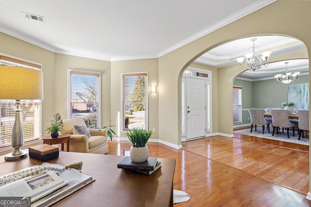 interior space with hardwood / wood-style flooring, ornamental molding, and a chandelier