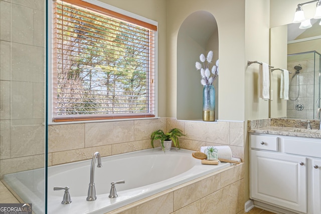 bathroom with vanity and shower with separate bathtub