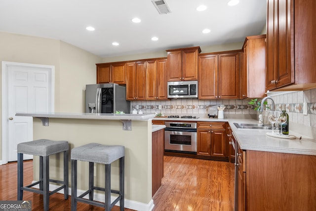 kitchen with stainless steel appliances, a center island, sink, and a breakfast bar area