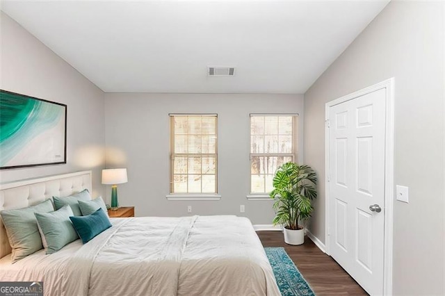 bedroom with lofted ceiling and dark hardwood / wood-style flooring