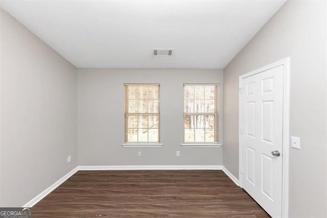 empty room with dark hardwood / wood-style flooring