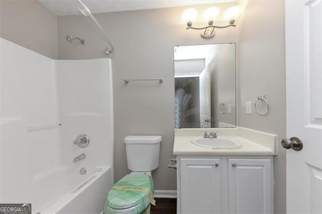 full bathroom with  shower combination, toilet, vanity, and a textured ceiling