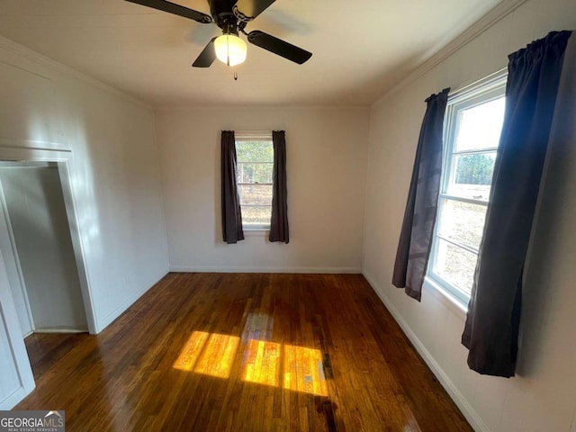 unfurnished room featuring dark wood-type flooring, ornamental molding, and ceiling fan