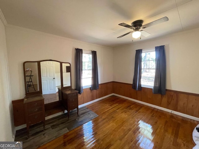 unfurnished office with crown molding, ceiling fan, dark hardwood / wood-style floors, and wood walls