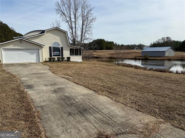 view of property exterior with a garage, a water view, and a lawn