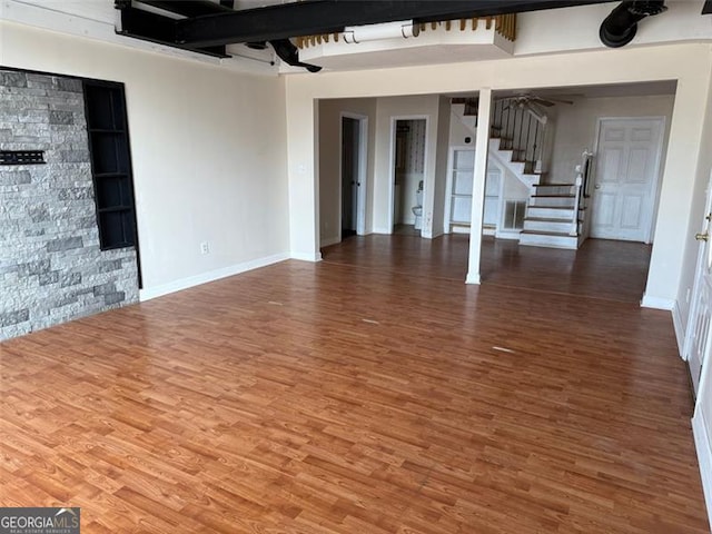 unfurnished living room with wood-type flooring and ceiling fan