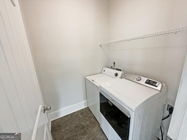 laundry room with dark tile patterned flooring and washer and dryer