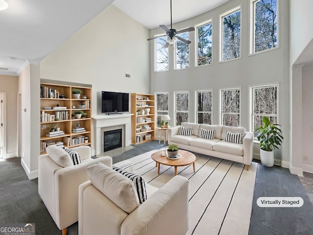 living room featuring ceiling fan and a high ceiling