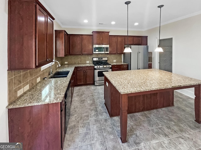 kitchen with sink, a breakfast bar area, appliances with stainless steel finishes, hanging light fixtures, and a center island