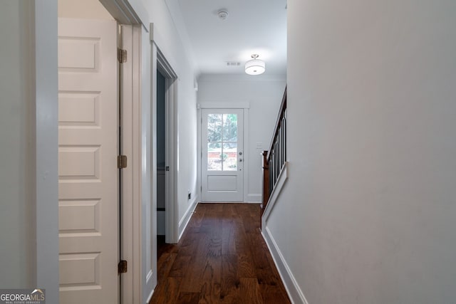 corridor featuring dark wood-type flooring and ornamental molding