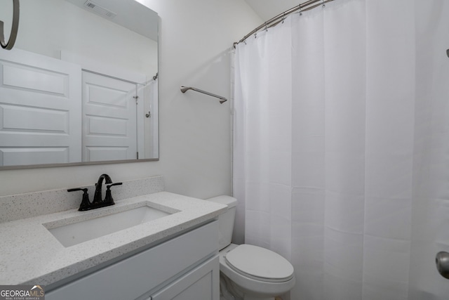 bathroom featuring walk in shower, vanity, and toilet