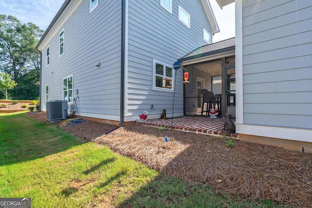 view of property exterior featuring a yard, a patio area, ceiling fan, and central air condition unit