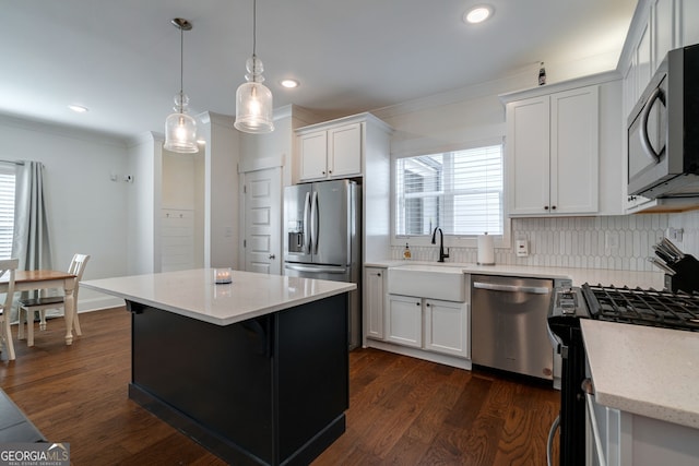 kitchen with sink, white cabinetry, hanging light fixtures, stainless steel appliances, and a center island