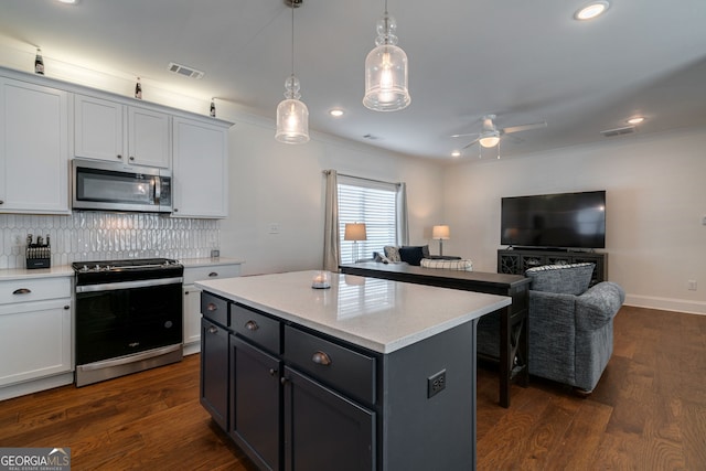 kitchen with a kitchen island, dark hardwood / wood-style floors, white cabinetry, hanging light fixtures, and stainless steel appliances