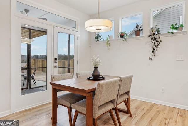 dining room with french doors and light hardwood / wood-style floors