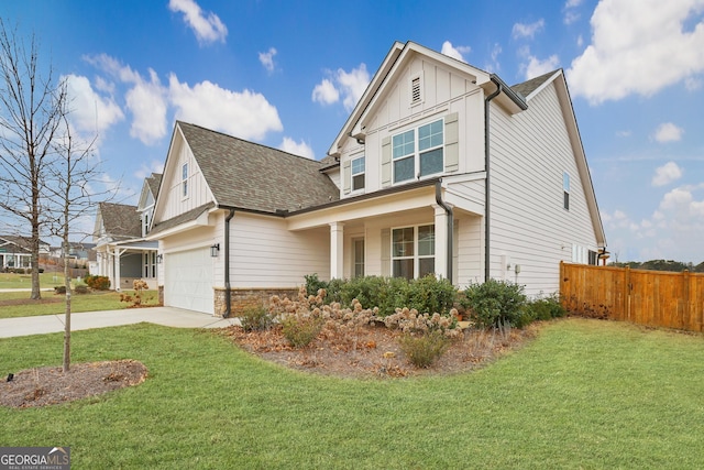 view of front of property featuring a garage, a front yard, and covered porch