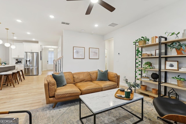 living room with ceiling fan and light wood-type flooring