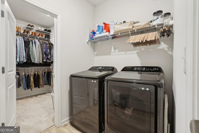 laundry area with washer and dryer and light wood-type flooring