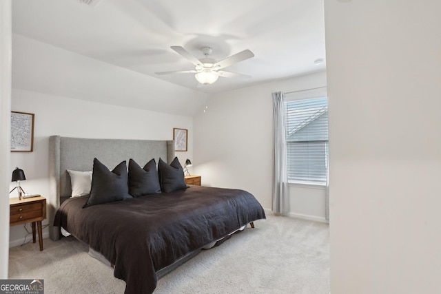 bedroom with vaulted ceiling, light colored carpet, and ceiling fan