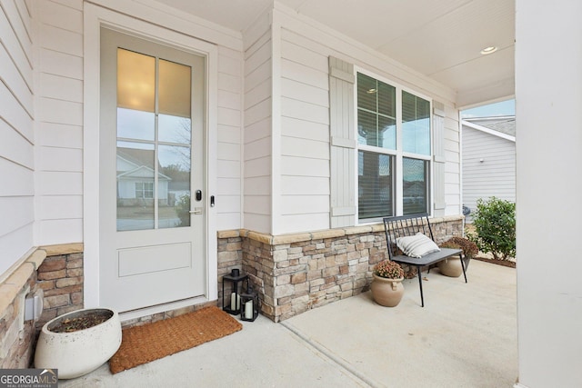 view of exterior entry featuring covered porch