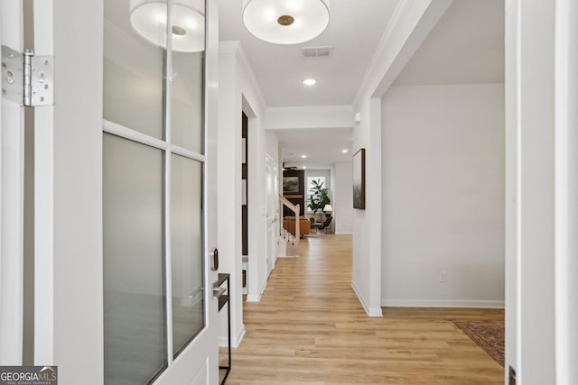 corridor with crown molding and light wood-type flooring