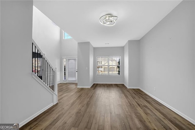 entrance foyer with stairway, plenty of natural light, wood finished floors, and baseboards