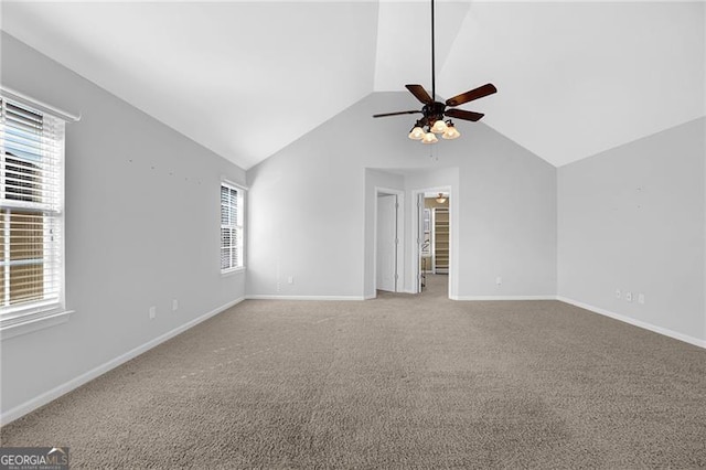 unfurnished room with vaulted ceiling, ceiling fan, light colored carpet, and baseboards