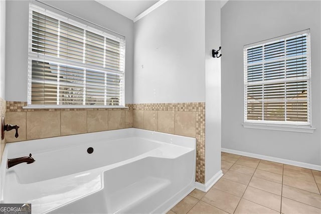 full bathroom featuring a garden tub, tile patterned flooring, and baseboards