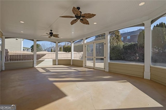 unfurnished sunroom with ceiling fan