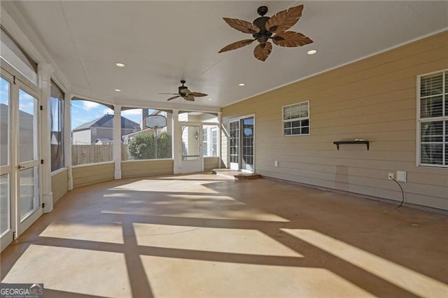 unfurnished sunroom featuring ceiling fan