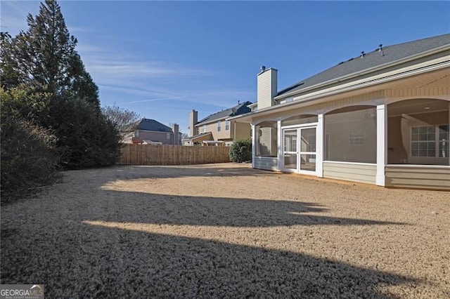 view of yard featuring fence and a sunroom