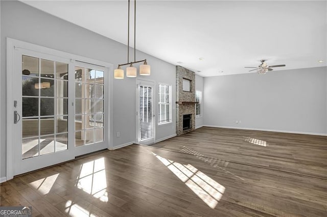 unfurnished living room featuring a fireplace, wood finished floors, a ceiling fan, and baseboards