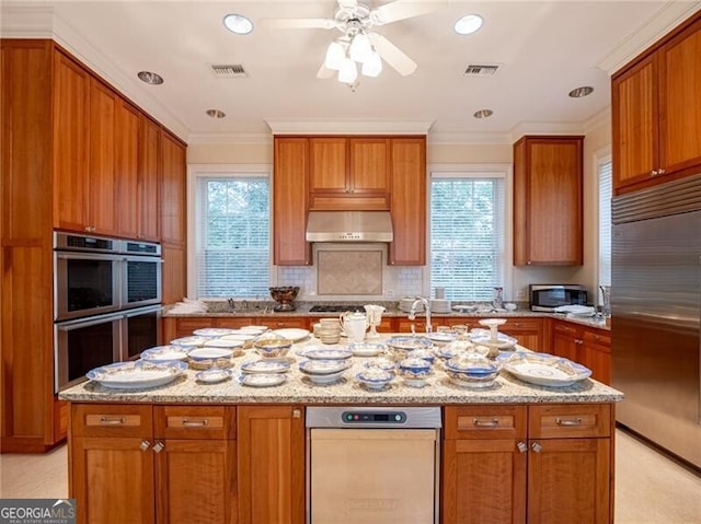 kitchen with light stone countertops, extractor fan, appliances with stainless steel finishes, and ornamental molding